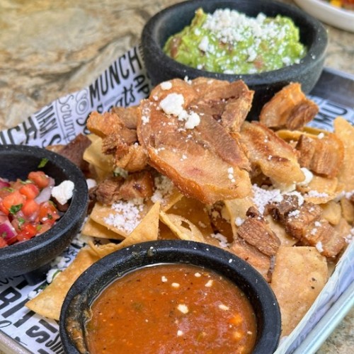 GUACAMOLE CON CHICHARRONES : Crispy, made-to-order chicharron paired with creamy guacamole, crumbled queso fresco, tangy red sauce, and cool sour cream.  $16